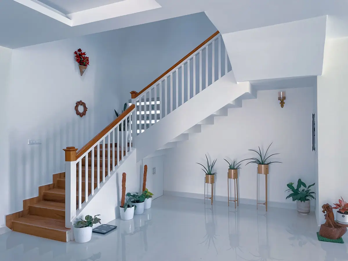 A white staircase rising from a bright hallway.