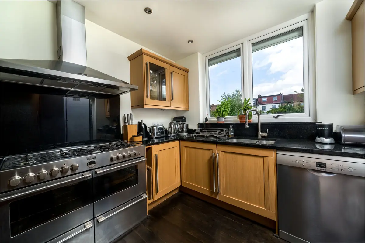 A range cooker under a stainless steel cooker hood.