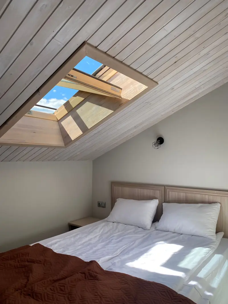 A bed under the roof window