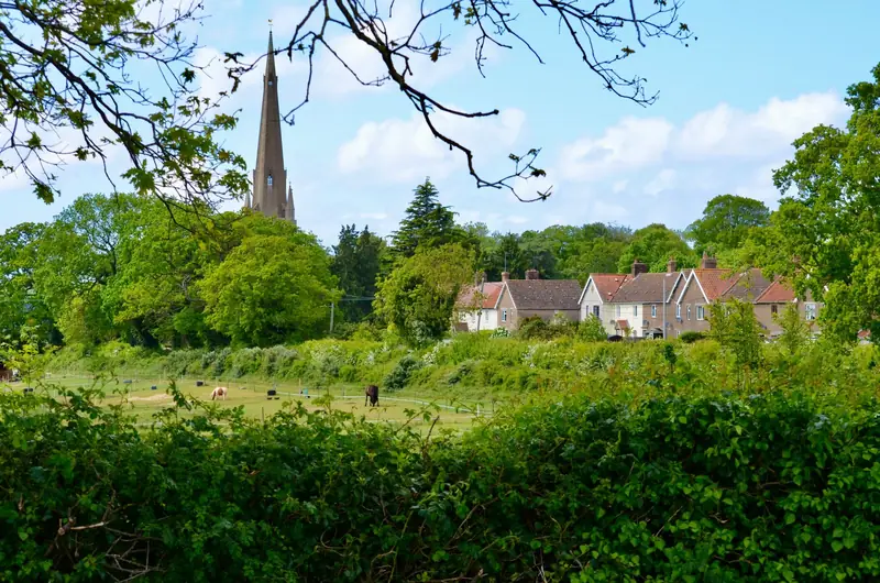 A village church spire above trees and fields