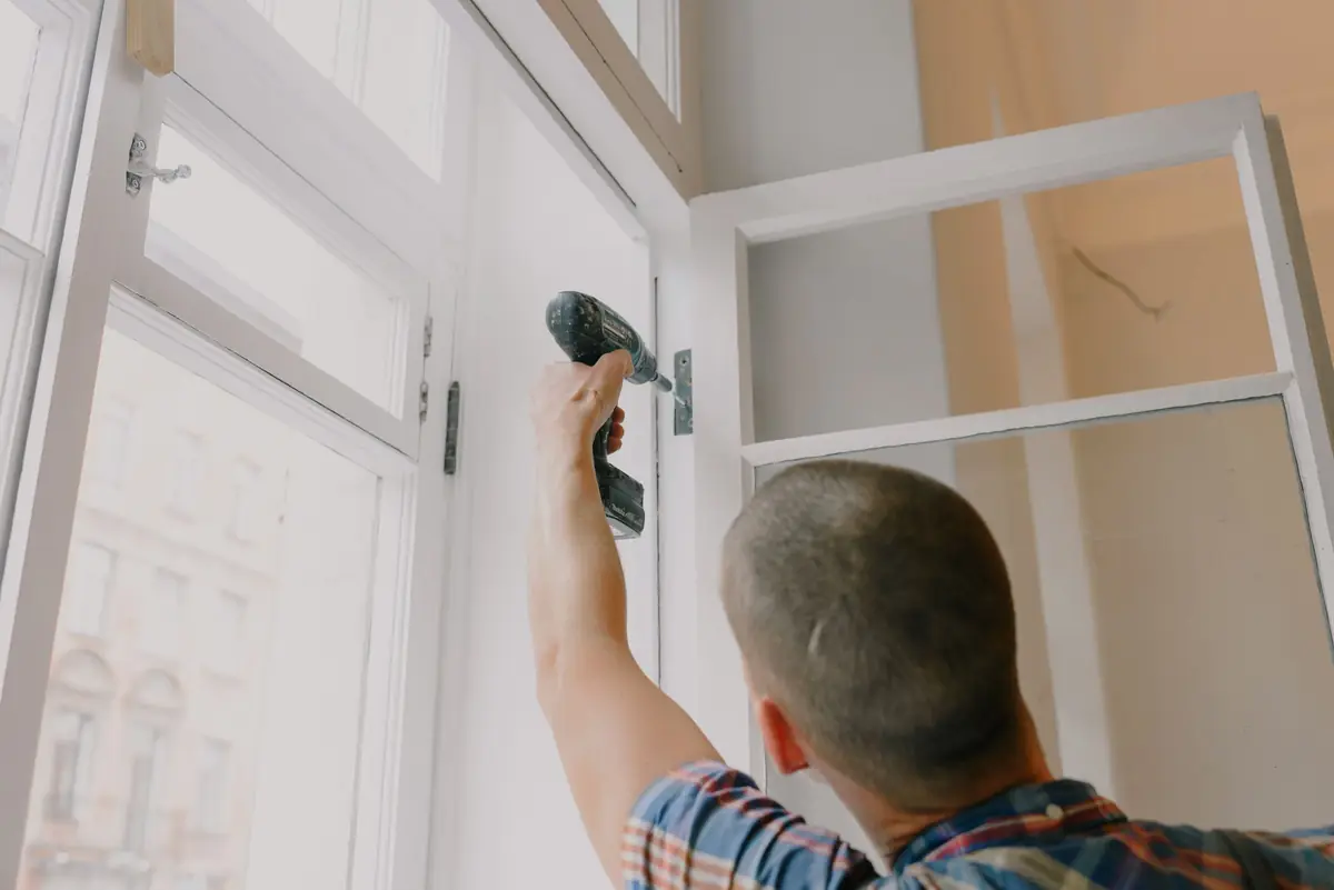 A builder fitting a new window frame.