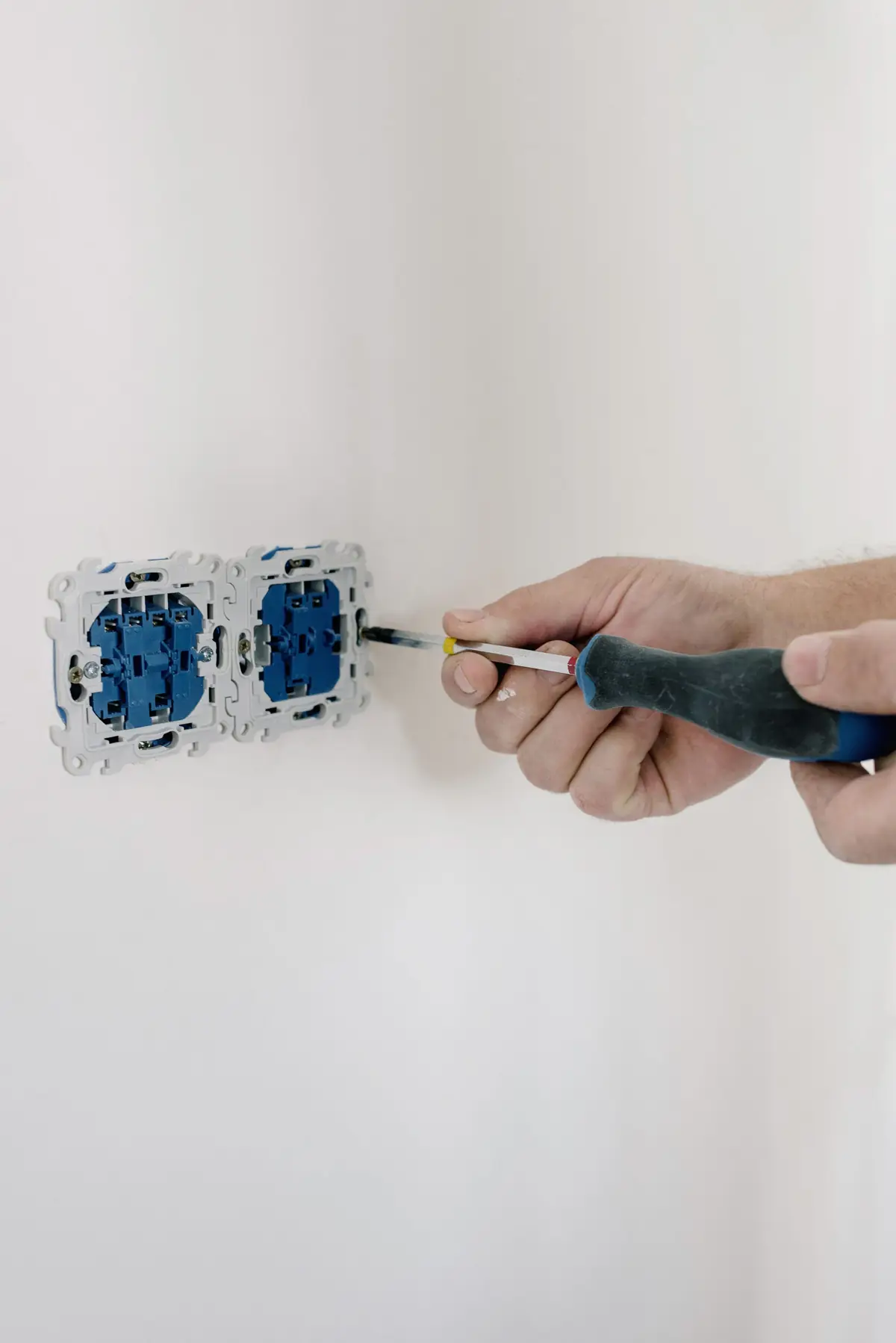 An electrician fitting a wall socket.