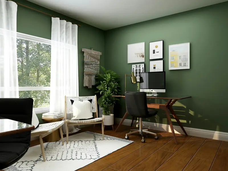 A home office with a green wall and a desk by the window