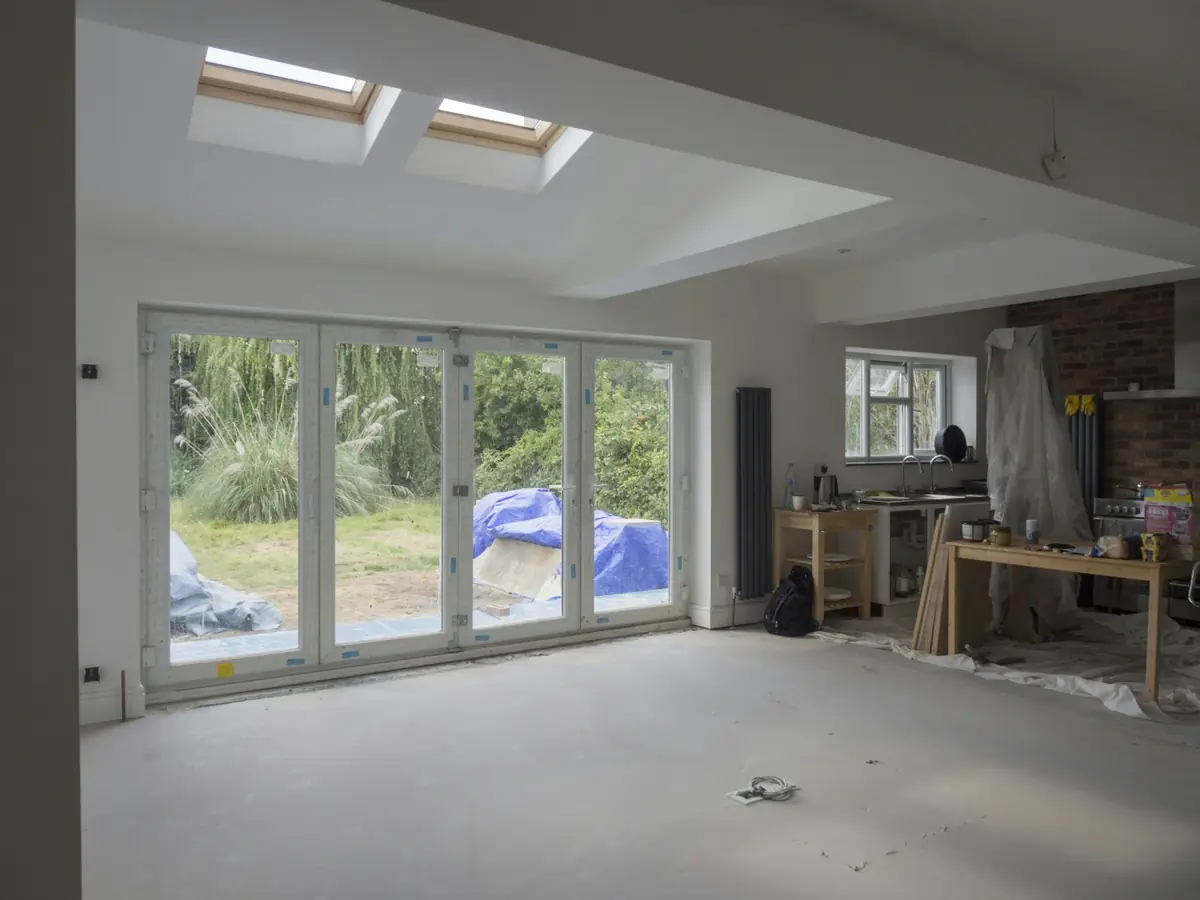 A garage conversion nearing the end, with new glass folding doors onto the garden and roof windows above.